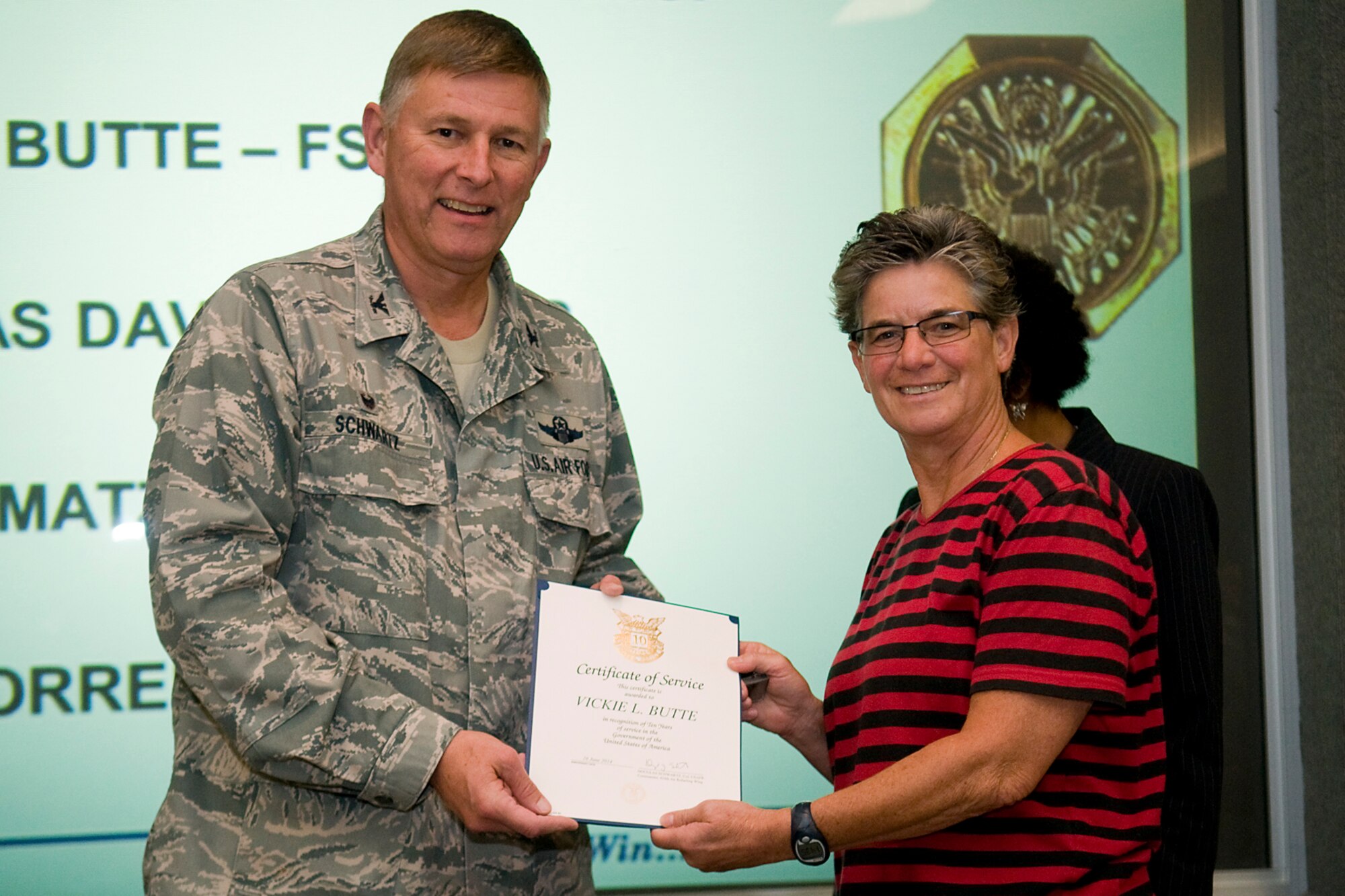 Col. Doug Schwartz, 434th Air Refueling Wing commander, presents Vickie Butte, 434th Force Support Squadron, with a certificate of service for completing 10 years as a federal employee during a civilian commander's call at Grissom Air Reserve Base, Ind., Aug. 13, 2014. Civil service employees are an essential part Grissom and serve critical roles in maintaining unit readiness and daily operations. (U.S. Air Force photo/Tech. Sgt. Mark R. W. Orders-Woempner)
