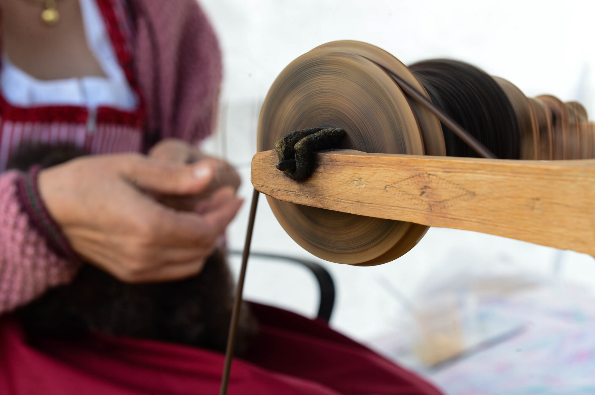 Monika Koster, a German civilian from Hosten, Germany, spins wool into string during a Diversity Day celebration at Spangdahlem Air Base, Germany, Aug. 21, 2014. Koster was a part of a cultural display for Spangdahlem’s diversity day celebration. This event highlighted the unity between different gender, racial and religious groups. (U.S. Air Force photo by Airman 1st Class Kyle Gese/Released)