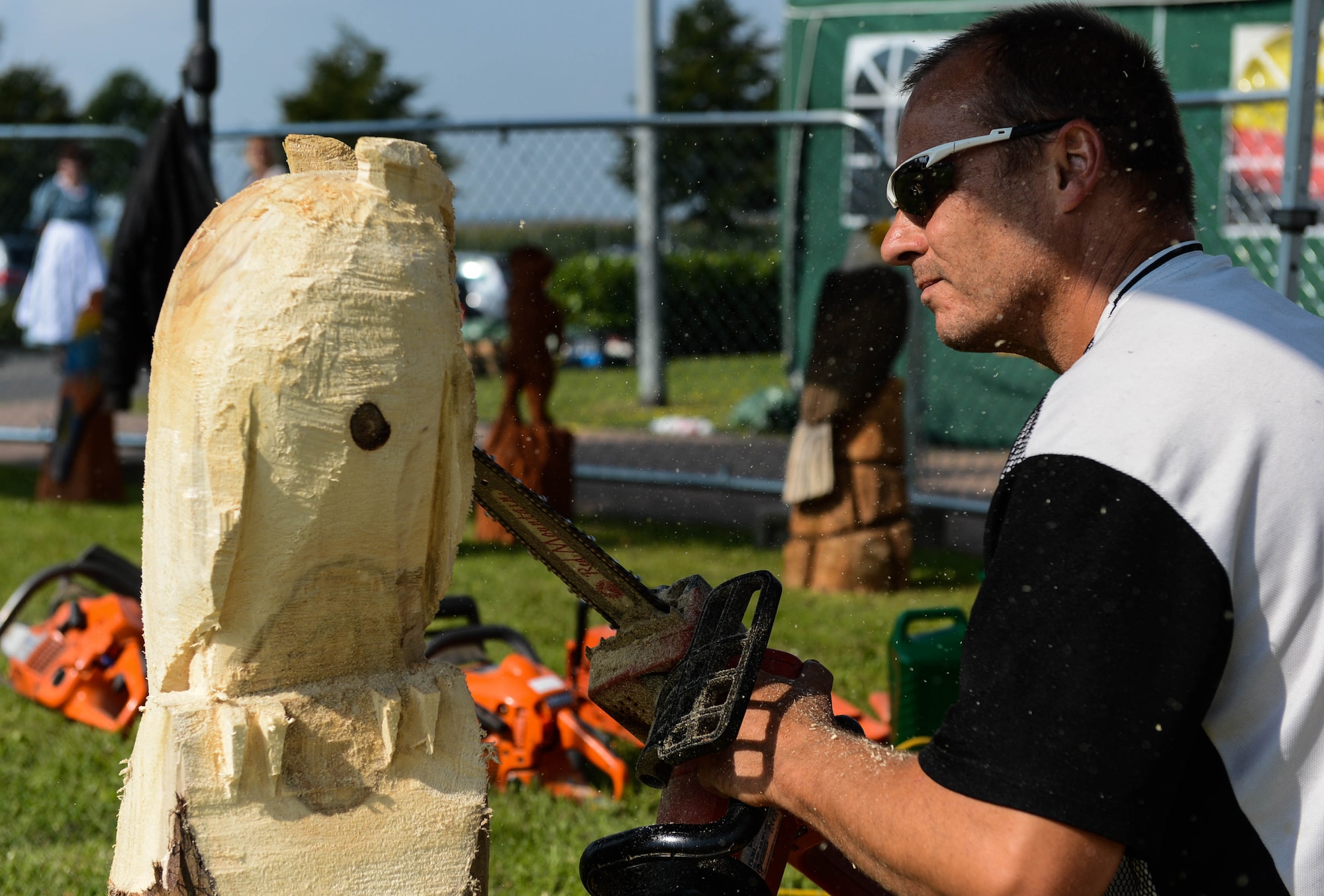 Dietmar Schier, a sculptor from Landscheid, Germany, uses a chainsaw to sculpt an owl during a Diversity Day celebration at Spangdahlem Air Base, Germany, Aug. 21, 2014. Event coordinators host Diversity Day each year to recognize the importance of mutual respect for others. (U.S. Air Force photo by Airman 1st Class Kyle Gese/Released)