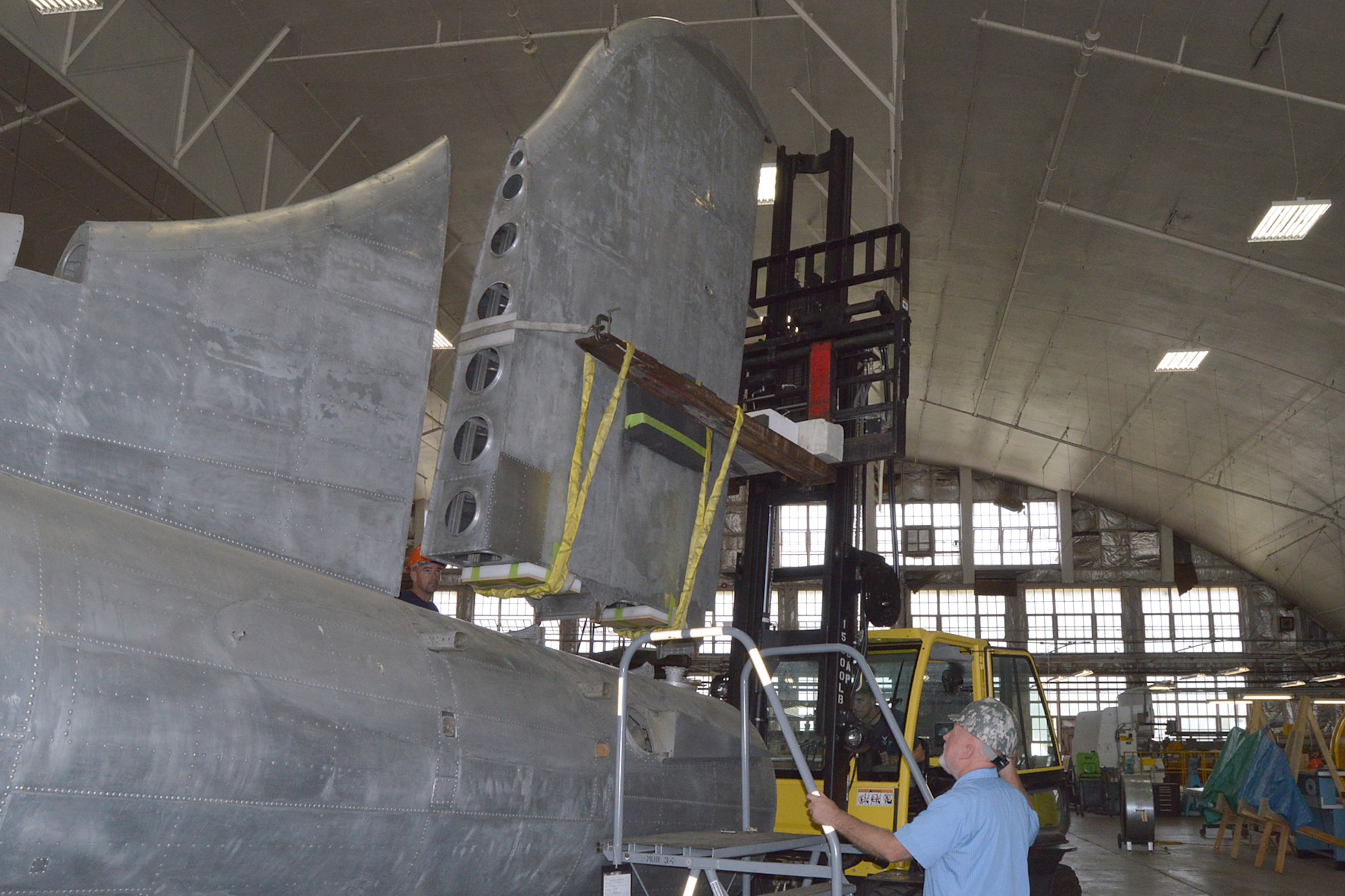 DAYTON, Ohio (08/2014) -- (From left to right) Restoration Specialists Duane Jones, Chad Vanhook, and Roger Brigner attach the vertical stabilizer to the fuselage of the B-17F "Memphis Belle"® at the museum's restoration hangar. Plans call for the aircraft to be placed on display in the museum's World War II Gallery in spring 2018. (U.S. Air Force photo)