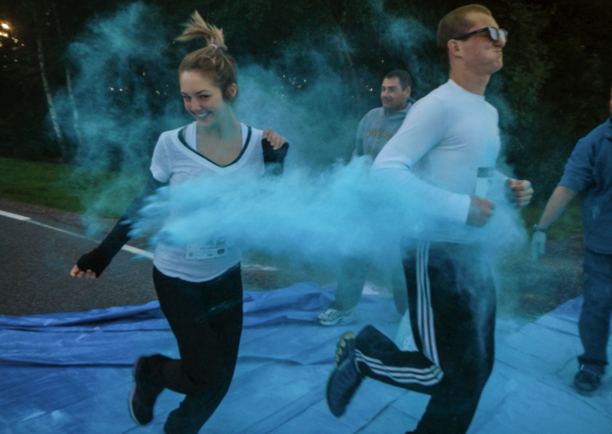 Participants are showered in color Aug. 21, 2014, during the Diversity Day 5K Color Run at Spangdahlem Air Base, Germany. Volunteers threw colored powder at participants at designated points on the route. (U.S. Air Force photo by Staff Sgt. Christopher Ruano/Released)