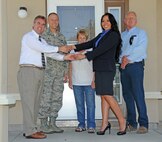 Balfour Beatty community manager Diana Torres receives the key to the final house of the housing privatization project from Tim Yonkers, Balfour Beatty construction manager, Aug. 18, 2014, at Beale Air Force Base, Calif. The project cost approximately $91 million and included 331 homes built, 505 unlivable homes demolished, and 178 homes renovated.  (U.S. Air Force photo by Airman 1st Class Ramon A. Adelan/Released) 
