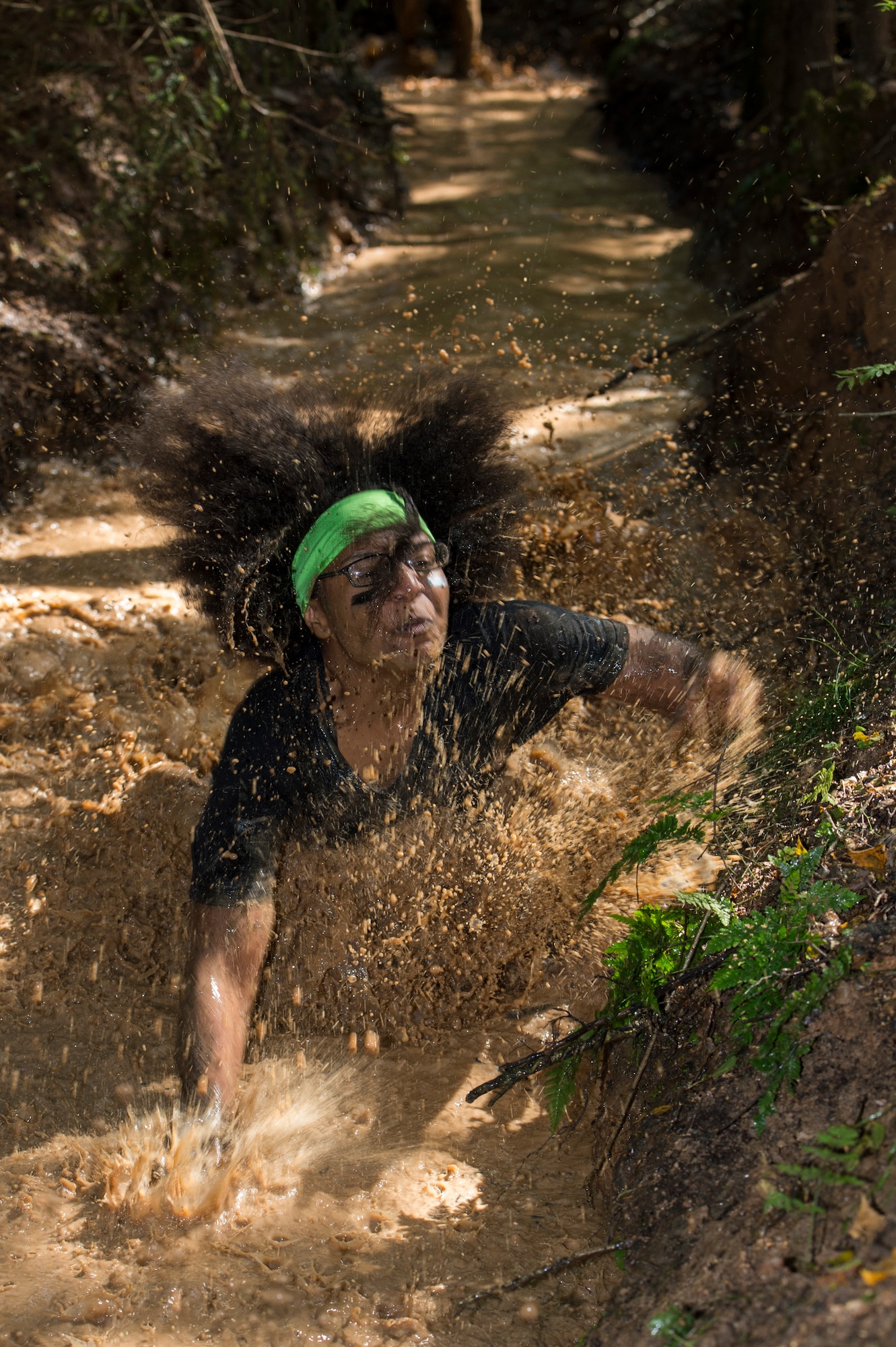 A mud run participant tumbles into the mud during the second annual Tier II 5K Mud Run Aug. 20, 2014, at Spangdahlem Air Base, Germany. More than 100 people participated in the mud run. Private organizations from around the base worked together to build the obstacles for runners. (U.S. Air Force photo by Staff Sgt. Christopher Ruano/Released)