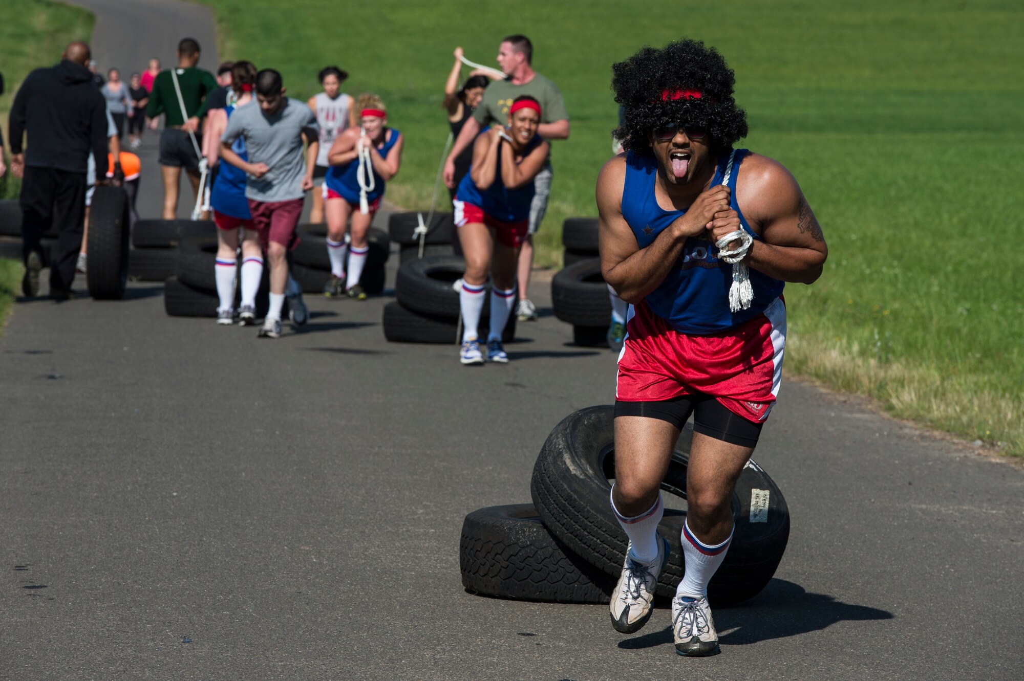 Mud run team members participate in a tire drag during the second annual Tier II 5K Mud Run Aug. 20, 2014, at Spangdahlem Air Base, Germany. Members were encouraged to form teams with each having unique themes and names. (U.S. Air Force photo by Staff Sgt. Christopher Ruano/Released)