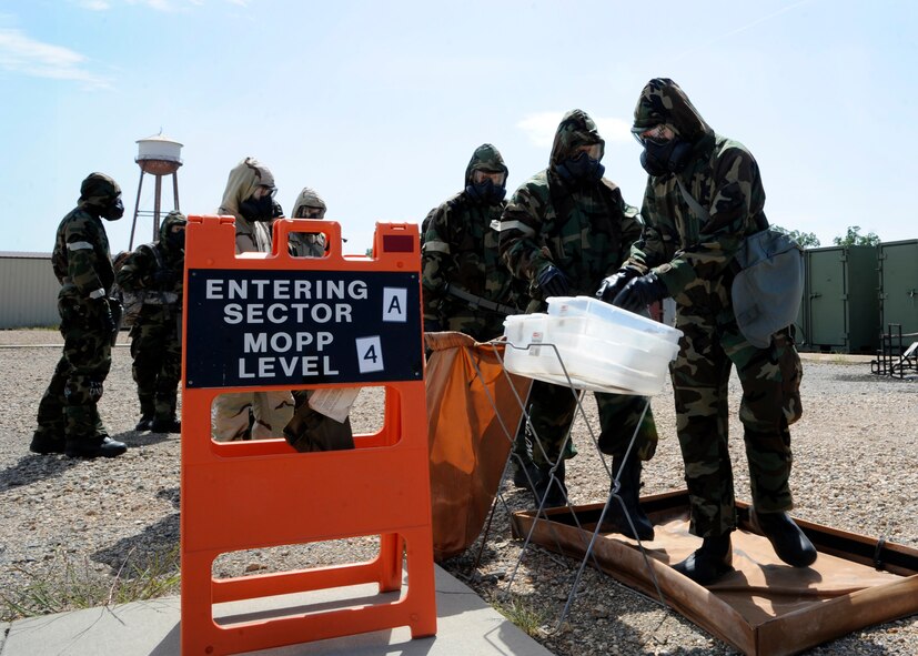 Airmen utilize a zone transition point to decontaminate their Mission Oriented Protective Posture gear during a chemical, biological, radiological, and nuclear defense survival skills class on Barksdale Air Force Base, La., Aug. 19, 2014. The zone was used to simulate what Airmen would do if they had been in contact with real chemical agents. (U.S. Air Force photo/Senior Airman Joseph A. Pagán Jr.)