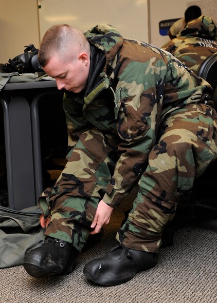 Senior Airman Kegan Hall, 2nd Security Forces Squadron game warden, puts on Mission Oriented Protective Posture gear during a chemical, biological, radiological, and nuclear defense survival skills class on Barksdale Air Force Base, La., Aug. 19, 2014. MOPP gear is used to protect individuals in contaminated environments. (U.S. Air Force photo/Senior Airman Joseph A. Pagán Jr.)