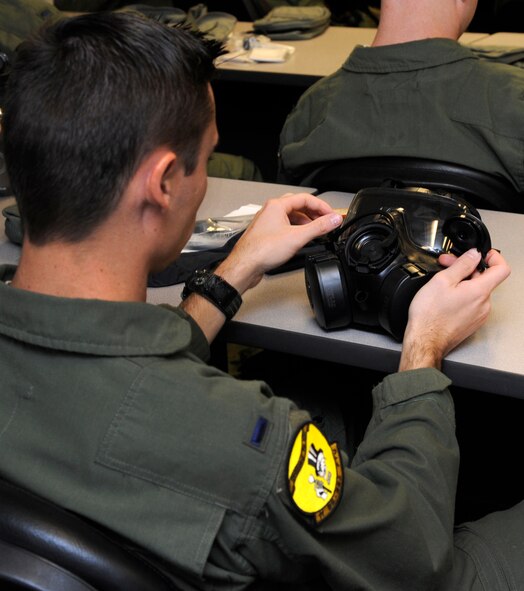 1st Lt. Kyle Thompson, 11th Bomb Squadron navigator, inspects an M-50 Joint Service General Purpose Mask during a chemical, biological, radiological, and nuclear defense survival skills class on Barksdale Air Force Base, La., Aug. 19, 2014. Thompson attended the CBRN class as part of his initial qualification training for flight operations. (U.S. Air Force/photo Senior Airman Joseph A. Pagán Jr.)