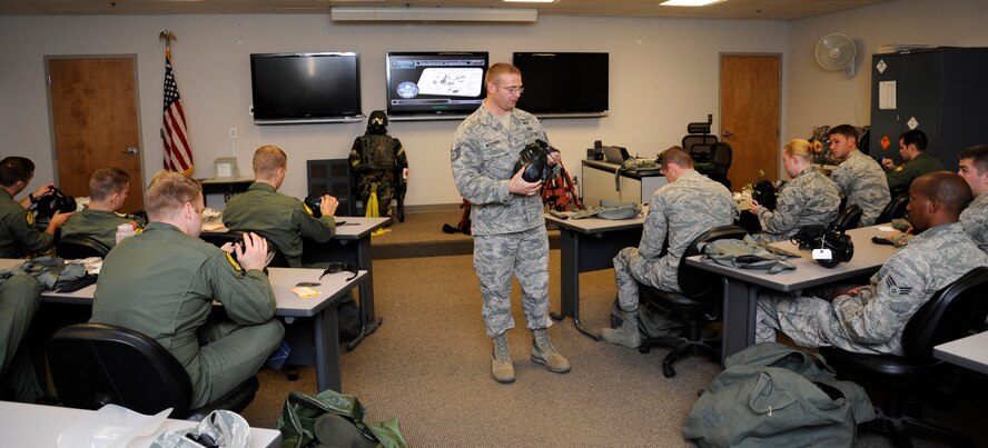 Tech. Sgt. Clinton McDaniel, 2nd Civil Engineer Squadron emergency management plans and logistics section chief, instructs Airmen on how to properly don a gas mask during a chemical, biological, radiological, and nuclear defense survival skills class on Barksdale Air Force Base, La., Aug. 19, 2014. The 2nd CES EM flight teaches the CBRN class several times a month to keep Barksdale Airmen up to date with their training requirements. (U.S. Air Force photo/Senior Airman Joseph A. Pagán Jr.)