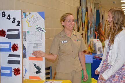 Navy Cmdr. Amy Smith, Naval Health Clinic Charleston director for administration, discusses  various health care topics with Emily Ollic, during Marrington Elementary's Back-To-School Night Aug. 14, 2014, at Marrington Elementary School on Joint Base Charleston, S.C. (U.S. Navy photo/Kris Patterson)
