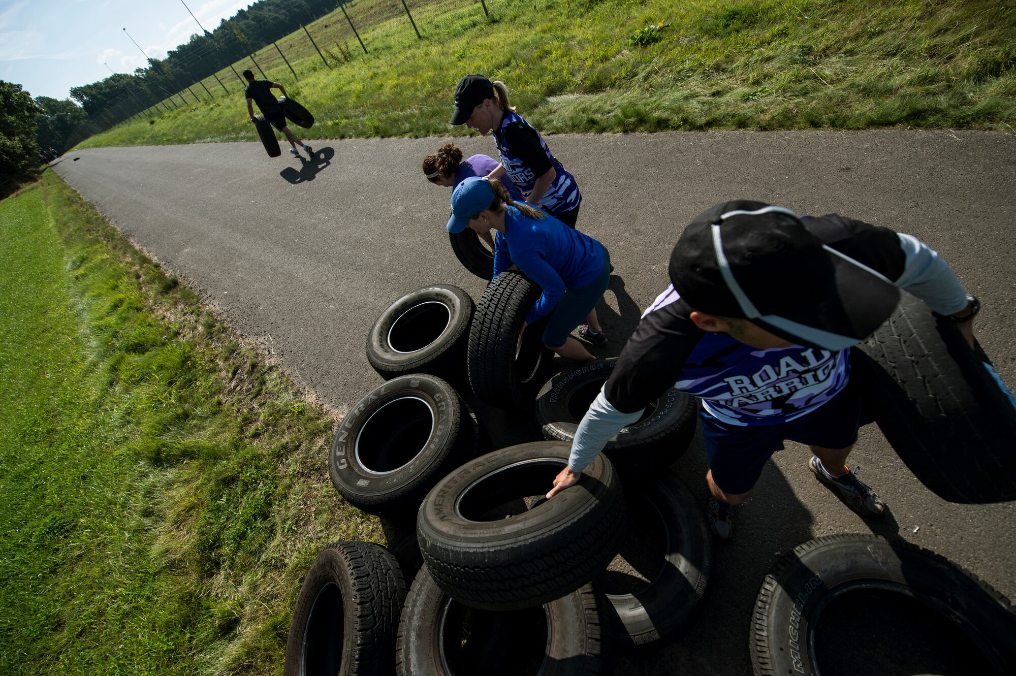 Team members participate in a tire drag during the second annual Tier II 5K Mud Run Aug. 20, 2014, at Spangdahlem Air Base, Germany. There were more than six obstacles on the course that Airmen had to complete. (U.S. Air Force photo by Senior Airman Rusty Frank/Released)