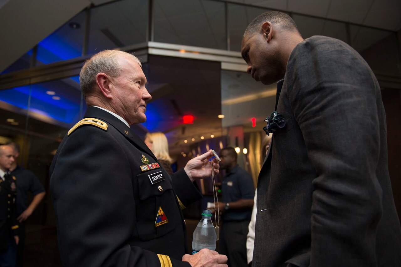 Army Gen. Martin E. Dempsey, left, chairman of the Joint Chiefs of Staff, shows off a dog tag before the U.S. national men’s basketball team’s exhibition game against the Dominican Republic at Madison Square Garden in New York, Aug. 20, 2014. DoD photo by U.S. Navy Petty Officer 1st Class Daniel Hinton