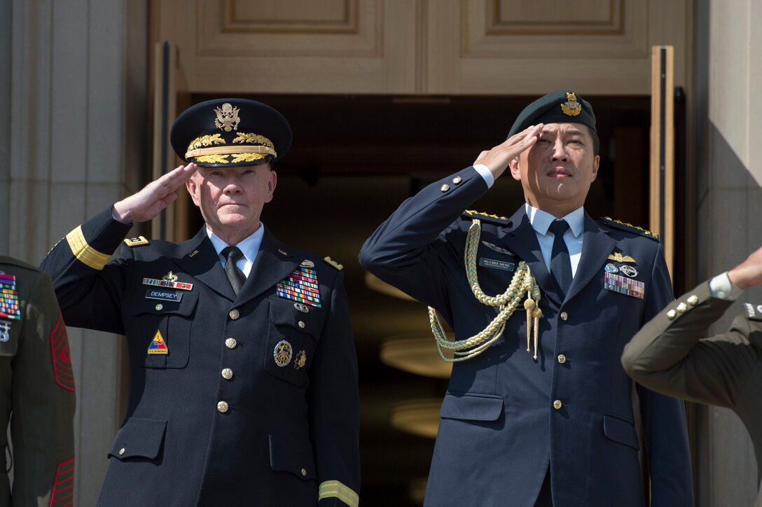U.S. Army Gen. Martin E. Dempsey, chairman of the Joint Chiefs of Staff, and Singaporean Chief of Defense Force Lt. Gen. Ng Chee Meng salute during an honor cordon on the steps of the Pentagon, Aug.  21, 2014.