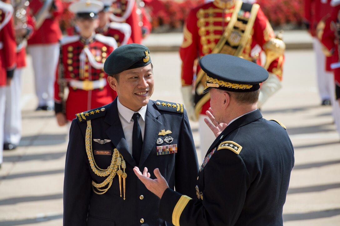 U.S. Army Gen. Martin E. Dempsey, right, chairman of the Joint Chiefs of Staff, talks with Singaporean Chief of Defense Force Lt. Gen. Ng Chee Meng in front of the Pentagon, Aug. 21, 2014.
