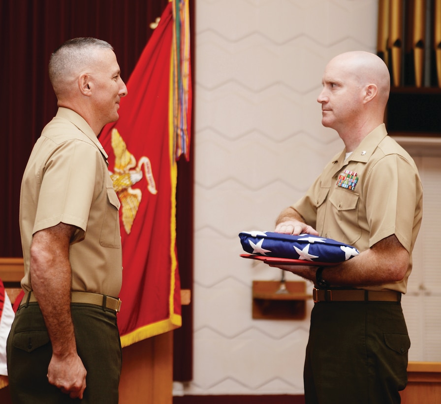 Lt. Col. Daniel L. Bates (right) outgoing executive officer, Marine Corps Logistics Base Albany, receives an American flag from MCLB Albany's Commanding Officer, Col. Don Davis, at Bates’ retirement ceremony at the Chapel of the Good Shepherd, Aug. 15. The flag was flown over Coffman Hall, Building 3500, in honor of 20 years of service to his country and the Corps, Aug. 14.