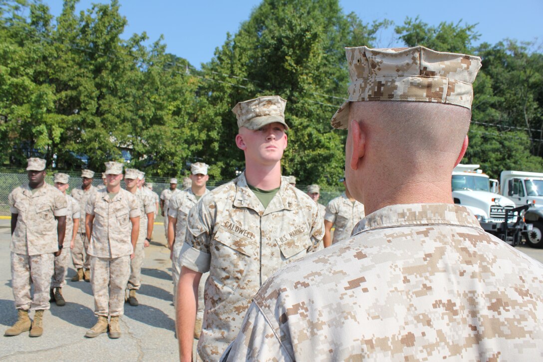 Col. David Maxwell, commander at Marine Corps Base Quantico, stands at attention in front of Pfc.Thomas Caldwell, motor transport operator at the Transportation Branch, on July 30, 2014, in the motor pool parking lot. Maxwell presented a letter of commendation, awarded by the Secretary of the Navy, Ray Mabus, to Caldwell for his support in the successful airlift of 1,000 Meals Ready to Eat to the Washington Navy Yard during the shooting incident last September. Master Sgt. Josue Santoyo, operations chief at Marine Corps Base Quantico, was also honored in separate ceremony.