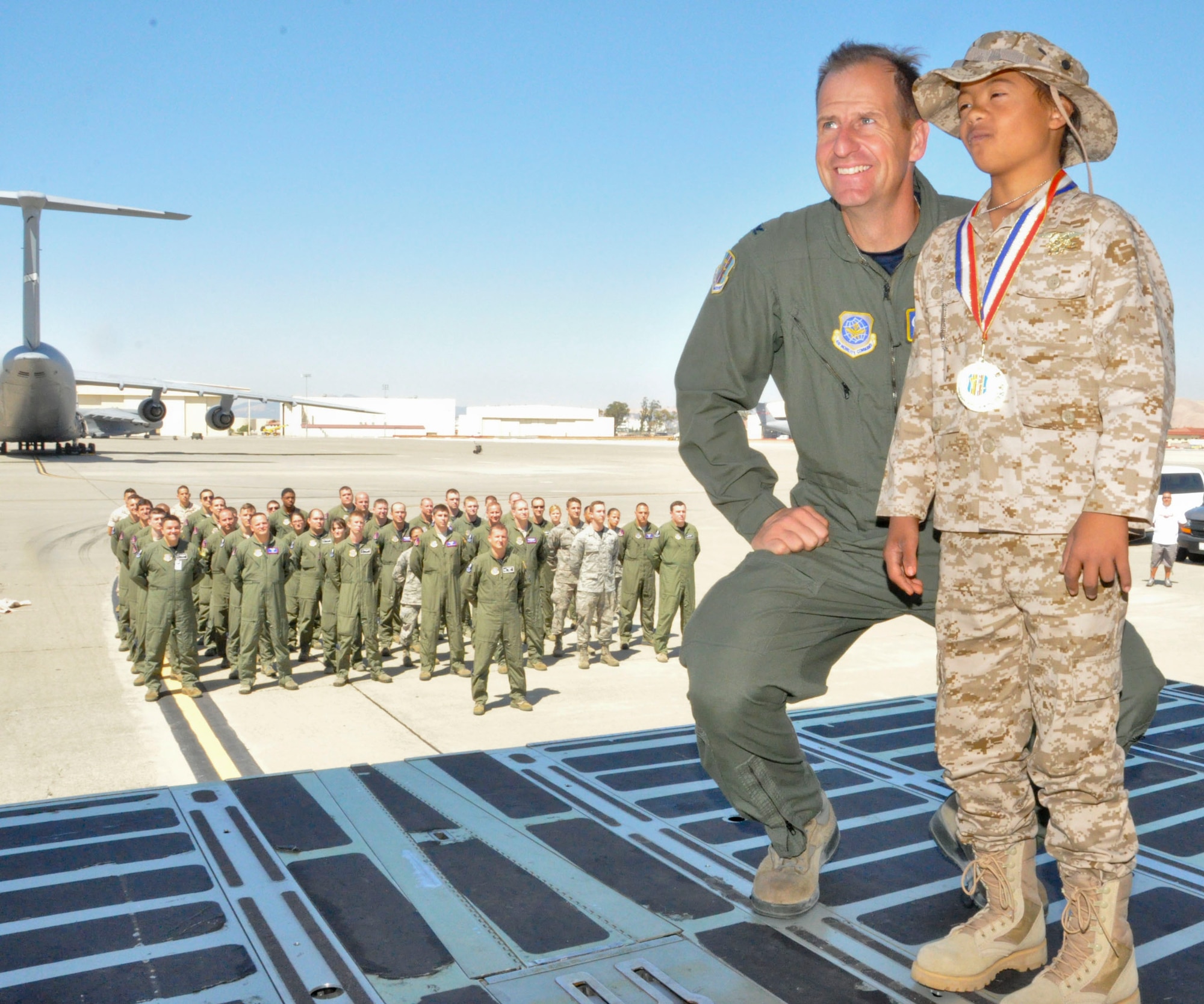 Col. Corey Martin poses with D’Marrion Otten Aug. 15, 2014, at Travis Air Force Base, Calif. D’Marrion was given a Hero’s welcome after spending the day defeating bad guys as a superhero to fulfill his wish submitted to the Make-a-Wish foundation. Martin is the 60th Air Mobility Wing commander. (U.S. Air Force photo/Airman 1st Class Amber Carter)