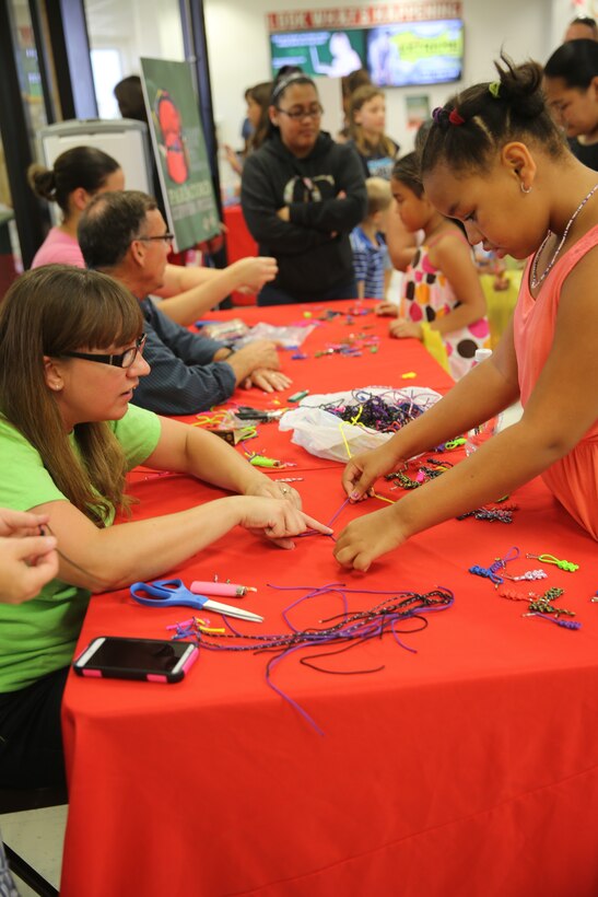 Children make backpack key chains as part of a back-to-school event at Marine Corps Air Station Cherry Point, Aug. 14, 2014. During the event, children of active-duty and reserve service members met with Disney Channel star Sabrina Carpenter for photos and autographs. The event also featured a healthy eating class where children learned what components make a healthy, well-balanced lunch. 
Craft stations were set up for children to make a key chain for their backpack and fill out a time capsule sheet to reopen at the end of the year for the children to see how their lives have changed. 
