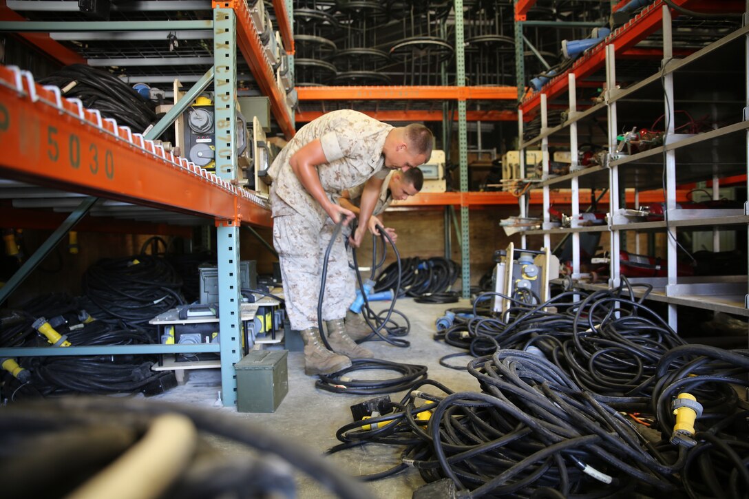 Lance Cpl. Nicholas Hanks and Lance Cpl. Jose Perez sort cables while performing preventative maintenance on a mobile electric power distribution unit at Marine Corps Air Station Cherry Point, N.C., Aug. 19, 2014. Hanks and Perez are both utilities electricians with Marine Wing Support Squadron-271.