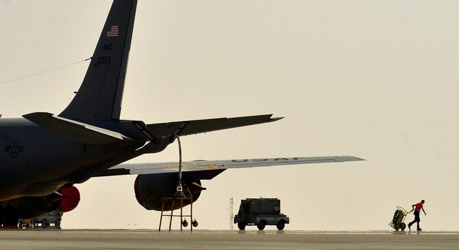 Heat rises from the flightline as Airman 1st Class Connor Sweeney moves equipment during a post flight inspection Aug. 5, 2014, at Al Udeid Air Base, Qatar. During post-flight inspections, the hydraulic systems craftsmen ensure the boom is functional and prepared for the next in-air refueling mission. Sweeney is a 340th Expeditionary Aircraft Maintenance Unit hydraulic systems craftsman. (U.S. Air Force photo/Staff Sgt. Vernon Young Jr.)