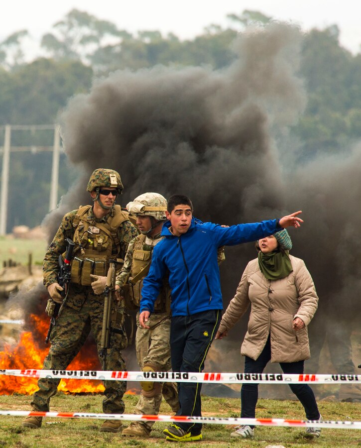 U.S. Marine Sgt. Cody Heinrichsen of 1st Battalion, 23rd Marines and a Chilean Marine escort an unruly citizen August 19, 2014 during a training scenario designed to simulate a major natural disaster as part of Partnership of the Americas 2014. Representatives from Argentina, Brazil, Canada, Chile, Colombia, Mexico, Paraguay, and the United States are participating in POA 2014 from August 11-22, 2014. This exercise is designed to enhance joint and combined interoperability, increase the combined capability to execute Amphibious Operations, Peace Support Operations, and Humanitarian Assistance/Disaster Relief missions, and further develop strong and lasting relationships the U.S. Marine Corps has established with partner nation’s naval infantries/marine corps.