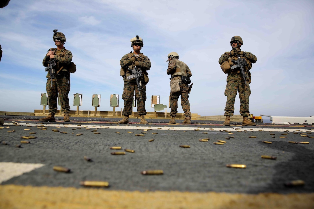 Marines with Special Purpose Marine Air Ground Task Force South standby after completing a live-fire exercise on the flight deck of the future amphibious assault ship USS America (LHA 6), Aug. 15, 2014. The purpose of the exercise was to refresh the Marines on weapons handling and marksmanship with the M4 service rifle and M9 service pistol. Training like this ensures that Marines with the SPMAGTF are prepared to provide our nation and partners with the capacity to respond immediately to a multitude of crisis. SPMAGTF-South is currently embarked aboard America on her maiden transit dubbed, “America Visits the Americas.”  (U.S. Marine Corps photo by Cpl. Christopher J. Moore/Released)
