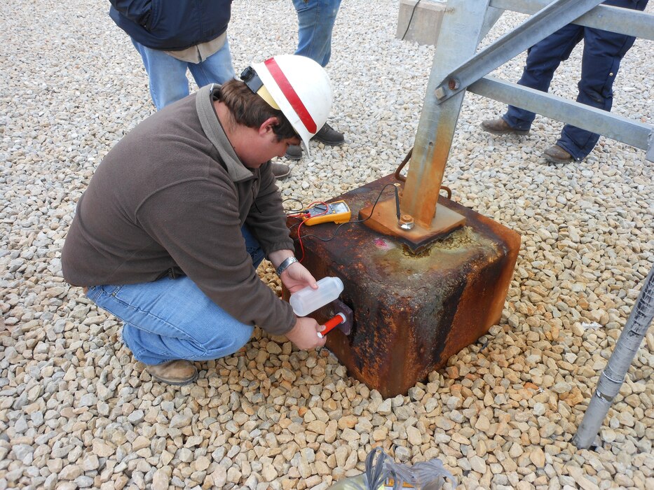 An ERDC engineer takes measurements on corrosion-damaged power transmission towers at Sam Rayburn Dam in Southeast Texas. 