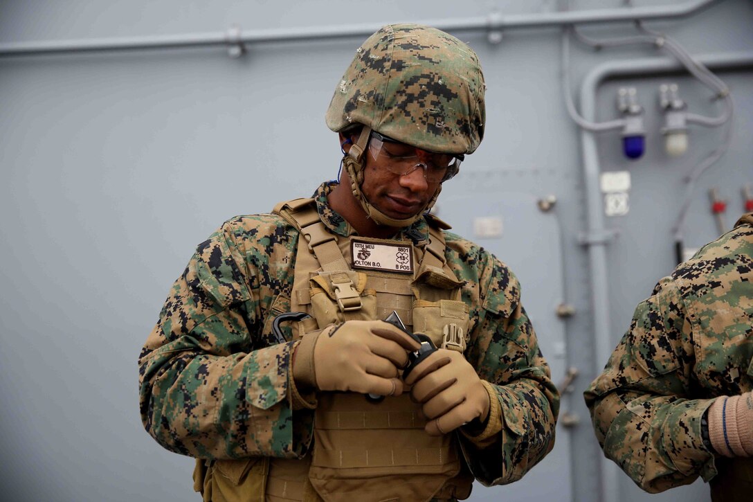 Petty Officer 3rd Class Brad Olton, U.S. Navy hospital corpsman with Special Purpose Marine Air Ground Task Force South, and a native of Orlando, Fla., loads his pistol magazine during a live-fire exercise on the flight deck of the future amphibious assault ship USS America (LHA 6), Aug. 15, 2014. The purpose of the exercise was to refresh the Marines on weapons handling and marksmanship with the M4 service rifle and M9 service pistol. Training like this ensures that Marines with the SPMAGTF are prepared to provide our nation and partners with the capacity to respond immediately to a multitude of crisis. SPMAGTF-South is currently embarked aboard America on her maiden transit dubbed, “America Visits the Americas.”  (U.S. Marine Corps photo by Cpl. Christopher J. Moore/Released)