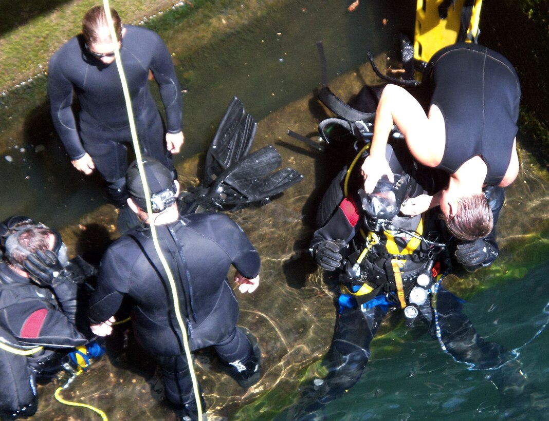 A Soldier diver, right, gets a last-minute check on his equipment from a fellow diver before submerging to a section of the inner wall of Phipott Dam during a routine inspection.  (USACE photo by Powell Hughes) 