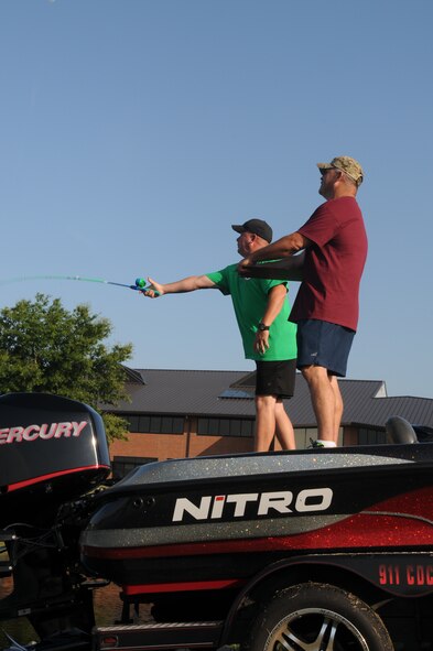 Airmen from the 188th Wing participate in a fishing pole casting contest during Wingman Day at Ebbing Air National Guard Base Fort Smith, Arkansas, on Aug. 2, 2014. Events included volleyball, a free throw contest, a 1.5 mile run, casting contest, golf chipping contest, golf cart driving course, and multiple fitness stations competition.  (U.S. Air National Guard photo by Airman 1st Class Cody Martin/released)