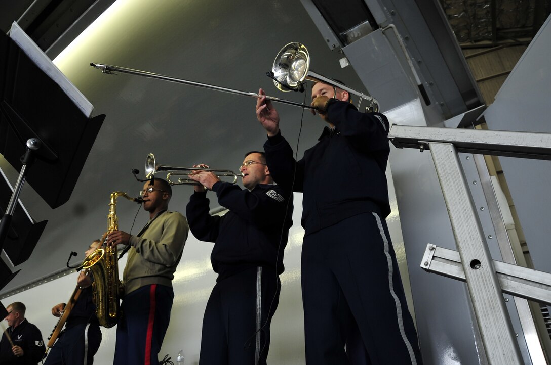 The horn section of Hana Hou performs with the group in a hangar for an appreciative crowd at the Arctic Thunder Air Show on Elmendorf Air Force Base in Anchorage, Alaska.  Pictured left to right: (borrowed from the Marine Corps) Corporal Raion Charles, Technical Sergeant Dave Diamond, and Technical Sergeant Ben Kadow.