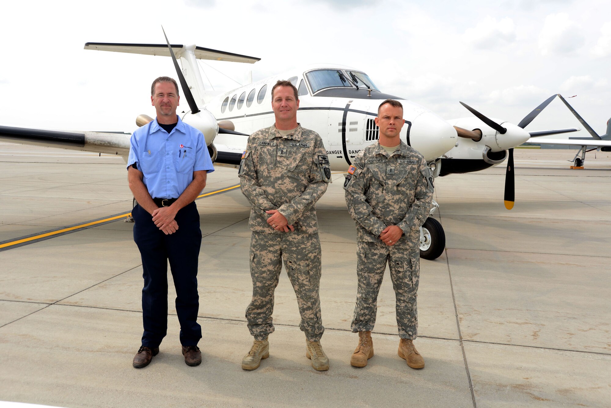 Members from the U.S. Army pose for a group photo on the flightline of Grand Forks Air Force Base, N.D., on Aug. 20, 2014. The Soldiers and Army civilian were part of large team that particiapted in the first ever Unmanned Aircraft Systems Airspace Integration Test in the U.S., which took place Aug. 4-22, 2014, at Grand Forks AFB. Manned Aircraft such as the King Air 200 behind them were also used in the joint test. (U.S. Air Force photo/Senior Master Sgt. David Lipp)
