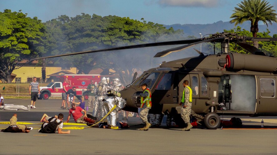 First responders from the 15th Wing, 154th Wing, Joint Base and local community respond to a simulated downed helicopter crash site during a major accident response exercise on the Joint Base Pearl Harbor-Hickam flightline Aug. 21, 2014. During the MARE, Airmen were moulaged and positioned near the crash site to test the emergency response of military and civilian first responders. (U.S. Air Force photo by Staff Sgt. Brian Miles)