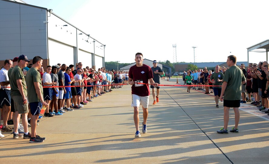 Airman 1st Class Austin Culp crosses the finish line of the 1.5 mile run in first place overall during Wingman Day at Ebbing Air National Guard Base Fort Smith, Arkansas, on Aug. 2, 2014. Culp completed the run with a time of 8:33 minutes. Culp is assigned to the 188th Operations Support Squadron. (U.S. Air National Guard photo by Senior Airman Hannah Landeros/Released)