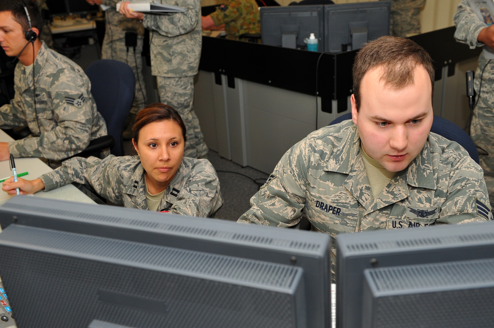 Senior Airman John Draper, 460th Operations Support Squadron, right, works with Capt. Monique Bramlette, 8th Space Warning Squadron, left, to overcome an array of challenges presented during the 460th Operations Group Panther Challenge Aug. 8, 2014, on Buckley Air Force Base, Colo. The challenge, held Aug. 4-13, was developed to provide members of Team Buckley an opportunity to improve their skills and expand their job knowledge in a competitive setting. Participants in the challenge included the 2nd and 8th Space Warning Squadrons, 460th Security Forces Squadron, and 460th Medical Group. (U.S. Air Force photo by Senior Airman Phillip Houk/Released)