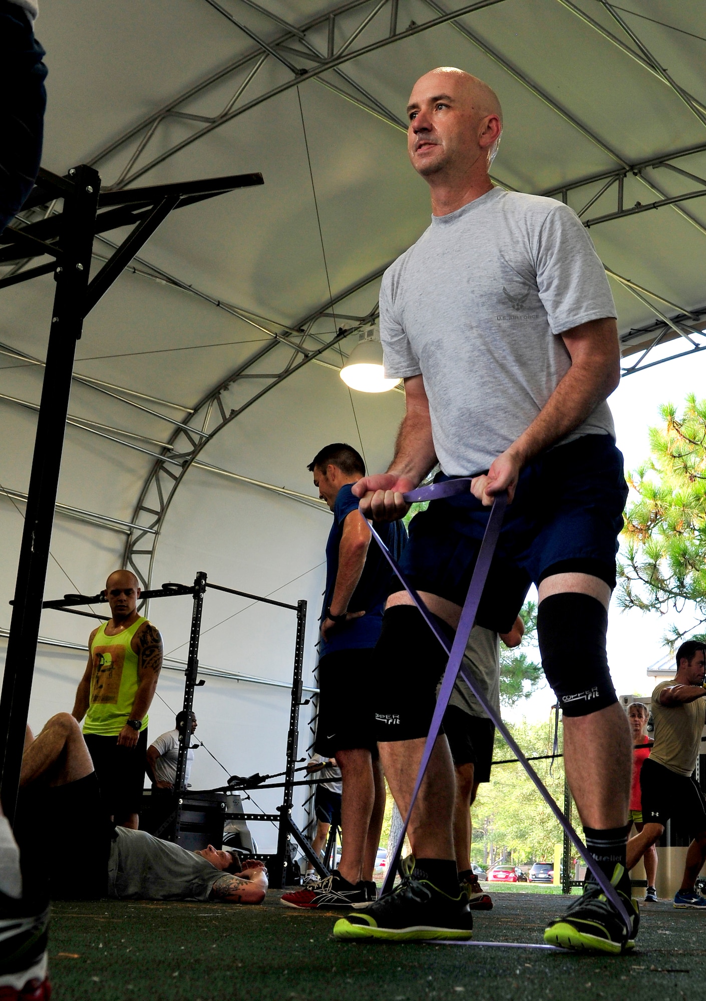 Chief Master Sgt. Jeffery Maberry, 1st Special Operations Wing Command Chief, uses strength bands during a, lateral movement, core exercise at the Aderholt Fitness Center, Hurlburt Field, Fla., Aug. 22, 2014. Fitness instructors taught Airmen to maximize strength through functional movements. (U.S. Air Force photo/Staff Sgt. Tyler Placie)