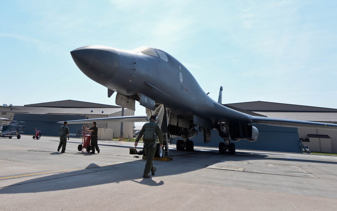 Aircrew members assigned to the 34th Bomb Squadron perform pre-flight checks during a walk-around-inspection of a B-1 bomber as part of a stand-off weapons integration exercise at Ellsworth Air Force Base, S.D., Aug. 13, 2014. The stand-off weapons integration training exercise was developed by B-1 aviators, and B-52 Stratofortress bomber crews assigned to the 23rd Bomb Squadron, Minot Air Force Base, N.D., to create an integrated mission plan involving simulated tactical scenarios to train for potential future operations. (U.S. Air Force photo by Senior Airman Zachary Hada/Released)