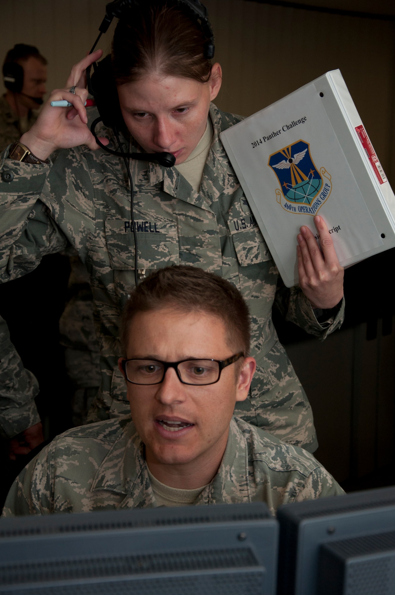 Tech. Sgt. Andrew Livingston, 8th Space Warning Squadron, seated, responds to a simulated event while Senior Airman Amber Powell, 460th Operations Support Squadron, evaluates his actions during the 460th Operations Group Panther Challenge Aug. 4, 2014, on Buckley Air Force Base, Colo. The challenge, held Aug. 4-13, was developed to provide members of Team Buckley an opportunity to improve their skills and expand their job knowledge in a competitive setting. Participants in the challenge included the 2nd and 8th Space Warning Squadrons, 460th Security Forces Squadron, and 460th Medical Group. (U.S. Air Force photo by Tech. Sgt. Kali L. Gradishar/Released)