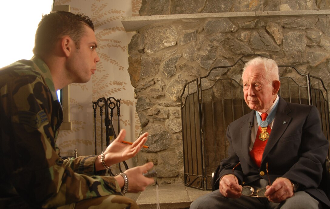 This archived photo shows then-Senior Airman Steven R. Doty, 8th Fighter Wing Public Affairs, interviewing retired Col. Bernard Fisher. Fisher and his wingman, Maj. Wayne Myers, ignored low clouds and repeatedly strafed the enemy with their A-1E Skyraiders. During one pass, Myers' aircraft was hit and caught fire and too low to bailout, Myers crash-landed his aircraft on the small and heavily damaged airstrip at the special forces camp and ran to cover alongside the runway. (U.S. Air Force photo by Staff Sgt. Darcie Ibidapo)(Released)