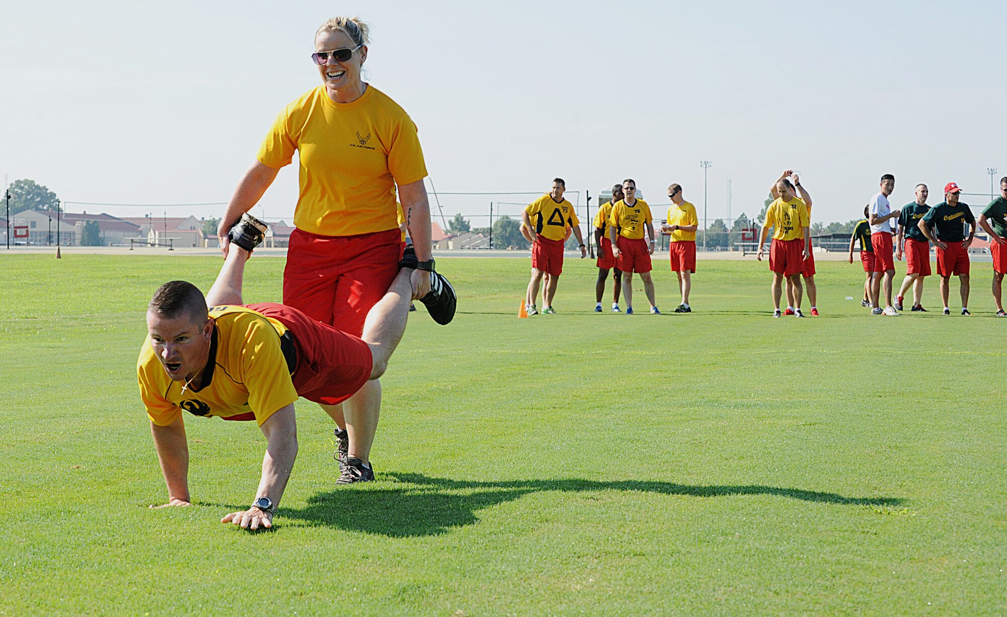 Capt. Johanna O’toole, 36th Student Squadron instructor, holds the legs of Capt. Joel Houseman, 36th STUS flight commander, during the wheelbarrow portion of The Great Squadron Officer College Tourney at Maxwell Air Force Base, Ala., Aug. 15, 2014. The tourney is designed to enhance camaraderie, problem-solving skills and fitness through teambuilding challenges. (U.S. Air Force photo by Staff Sgt. Erica Picariello)