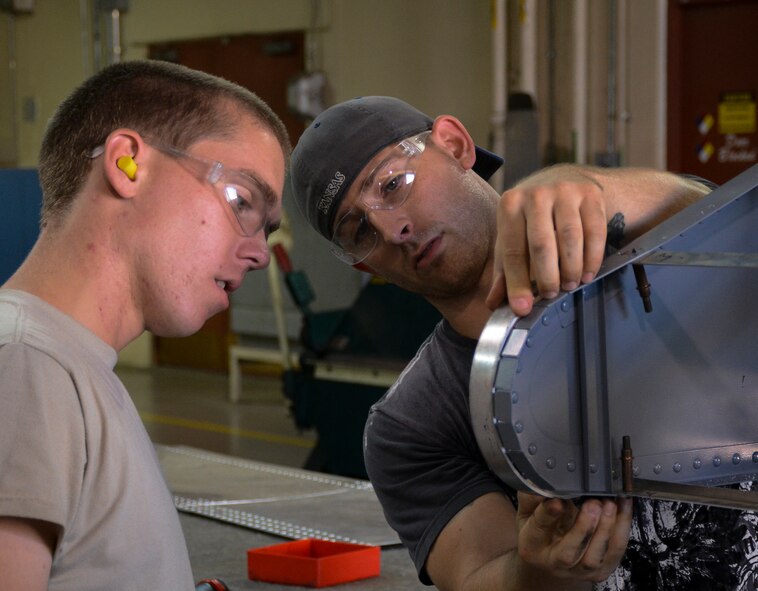 Staff Sergeant Adam Cross, right works with Senior Airman Ethan Pollock as he demonstrates the process of shaping a stiffner rib.  The Stiffner rib gives the leading edge on the simulated aircraft structure being built by the 507th Air Refueling Wing fabrication flight's sheet metal shop contour.  Technical Sergeant Harold Fulghum came up with the idea to build the simulator.  It gives sheet metal workers the opportunity to work on the leading edge of a KC-135R Stratotanker wing without the jet actually being broken.  (U.S. Air Force photo/Senior Airman Mark Hybers)
