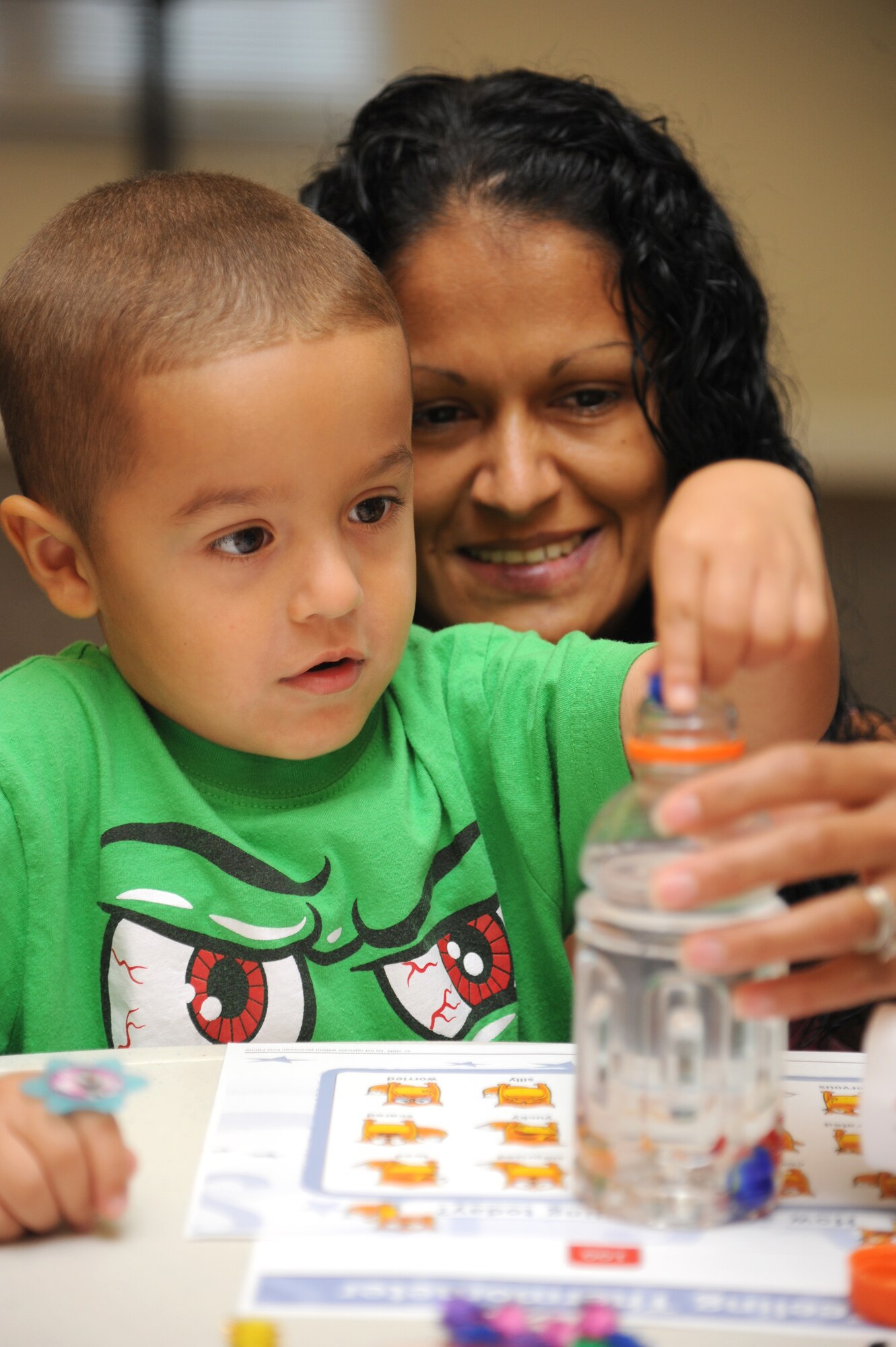 The son and wife of Navy Chief Petty Officer Jose Morales, Stennis Space Center, Miss., participate in an arts and crafts session hosted by Families OverComing Under Stress program Aug. 20, 2014, at the Forest City Community Center, Keesler Air Force Base, Miss. The FOCUS program provides resiliency training to service members and their families. The children also had the book, “Today I Feel Silly: and Other Moods That Make my Day” read to them during story time.  (U.S. Air Force photo by Kemberly Groue)