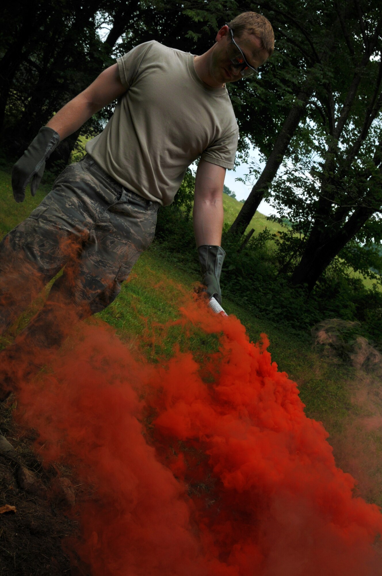 Airman First Class Kevin Forney of the 164th Airlift Squadron lights a survival flare while performing ground survival training at the Hamilton farm, Butler, OH, July 12, 2014. The 169th Air Support Operations Squadron (ASOS), of the 182nd Airlift Wing, Peoria, IL, assisted the Ohio Air Guard aircrew with the training. Four members of the 169th ASOS Tactical Air Patrol Party (TACP) teamed up to share their expertise in this training. The aircrew members are required to stay current in survival tactics and procedures on both land and water .(U.S. Air National Guard Photo by TSgt Joseph Harwood\Released)