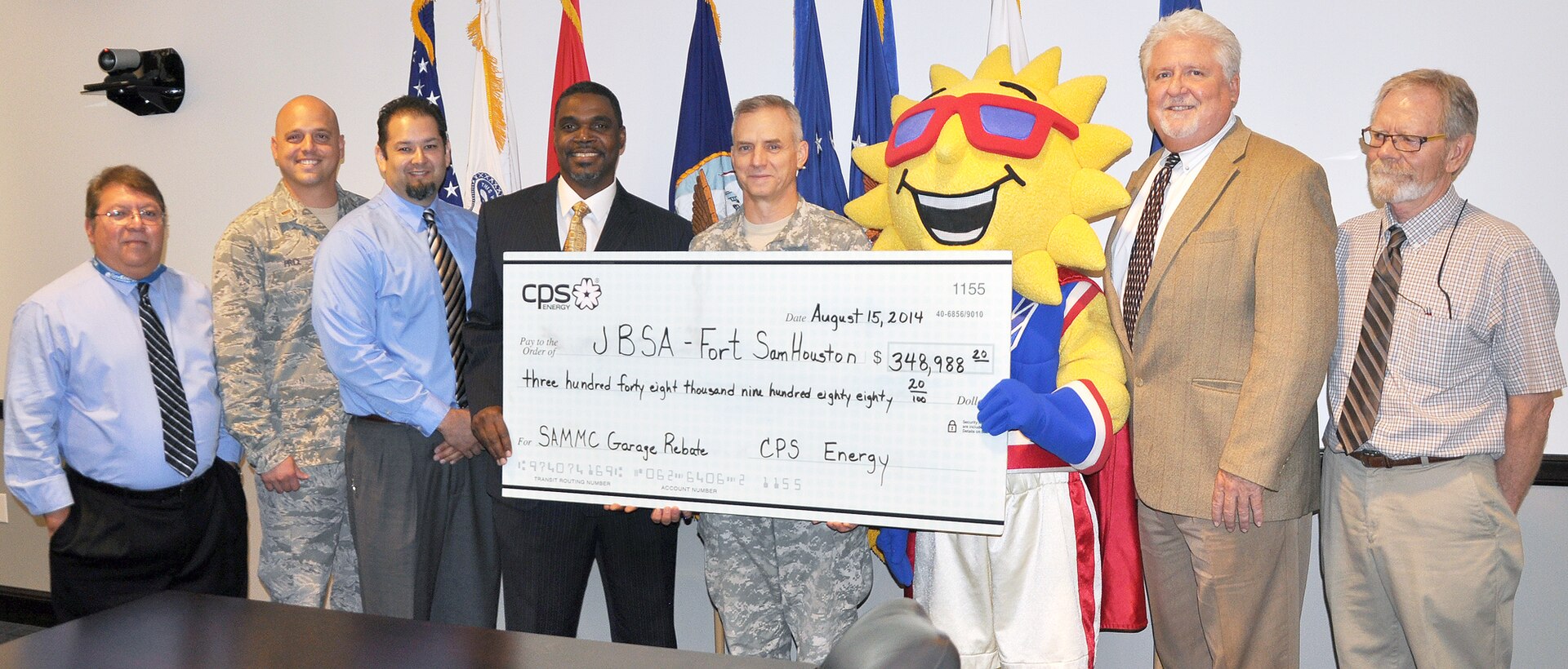 A $348,988 rebate check was presented at the 502nd Air Base Wing headquarters Aug. 15, thanks to a service contract between Joint Base San Antonio and the San Antonio utility company CPS Energy to upgrade lighting at the San Antonio Military Medical Center garage. Pictured at the rebate check presentation were (from left) Andy Hinojosa, JBSA energy manager; 2nd Lt. Christopher Price, 502nd Contracting Squadron; Alfred Canales, 502nd Civil Engineer Squadron engineer; Garrick Williams, JBSA Energy Solutions director with CPS Energy; Col. Jim Chevallier, 502nd ABW and JBSA deputy commander; “Ray” the CPS Energy mascot; Frank Thomas, Joint Base San Antonio resource efficiency manager; and Jerry McCall, JBSA-Fort Sam Houston energy manager.(Photo by Steve Elliott)
