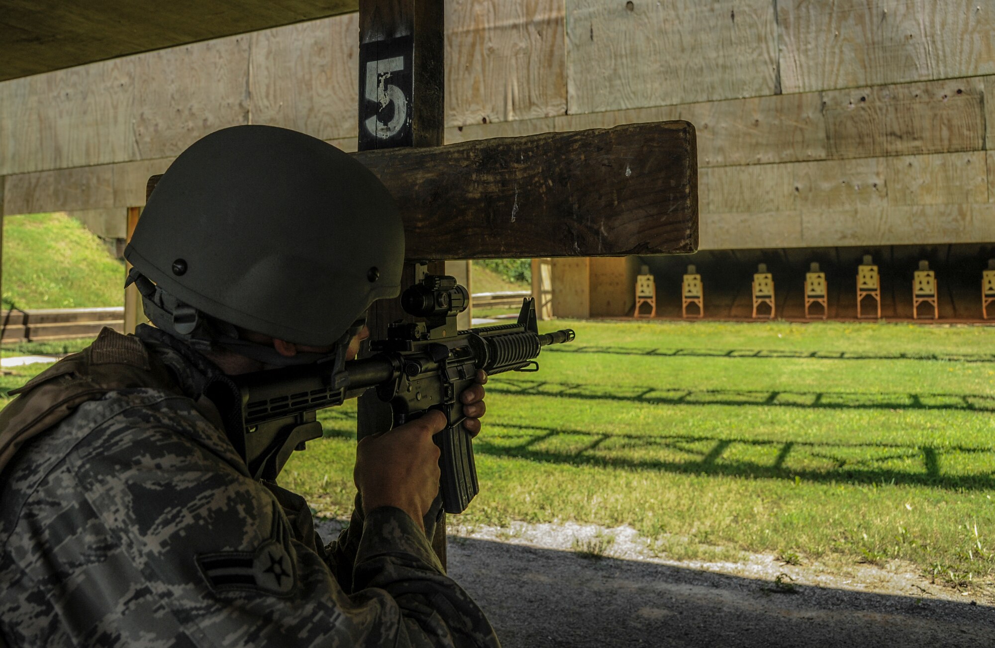 Airman 1st Class Christopher McEwen, a 19th Aircraft Maintenance Squadron crew chief, aims an M4 assault rifle toward a target Aug. 12, 2014, at Little Rock Air Force Base, Ark. The 19th Security Forces Squadron combat arms training and maintenance instructor team consists of only eight Airmen who work together to train 3,000-4,000 Airmen each year. (U.S. Air Force photo by Airman 1st Class Harry Brexel)