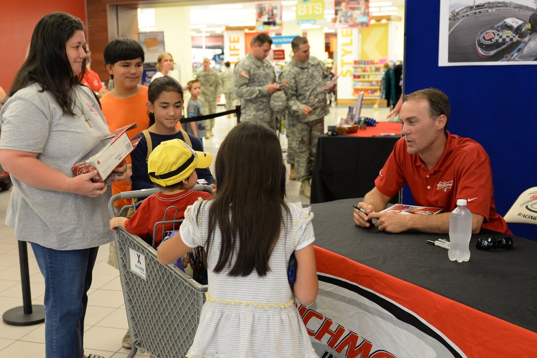 Kevin Harvick, NASCAR driver, signs autographs for U.S. Army Soldiers and families at the Exchange during a tour of Fort Eustis, Va., Aug. 20, 2014. Along with a stop at the Exchange, his visit included tours of the 128th Aviation Brigade and 3rd Port, as well as a stop at the 7th Transportation Brigade’s Resolute Dining Facility. (U.S. Air Force photo by Staff Sgt. Teresa J.C. Aber/Released)