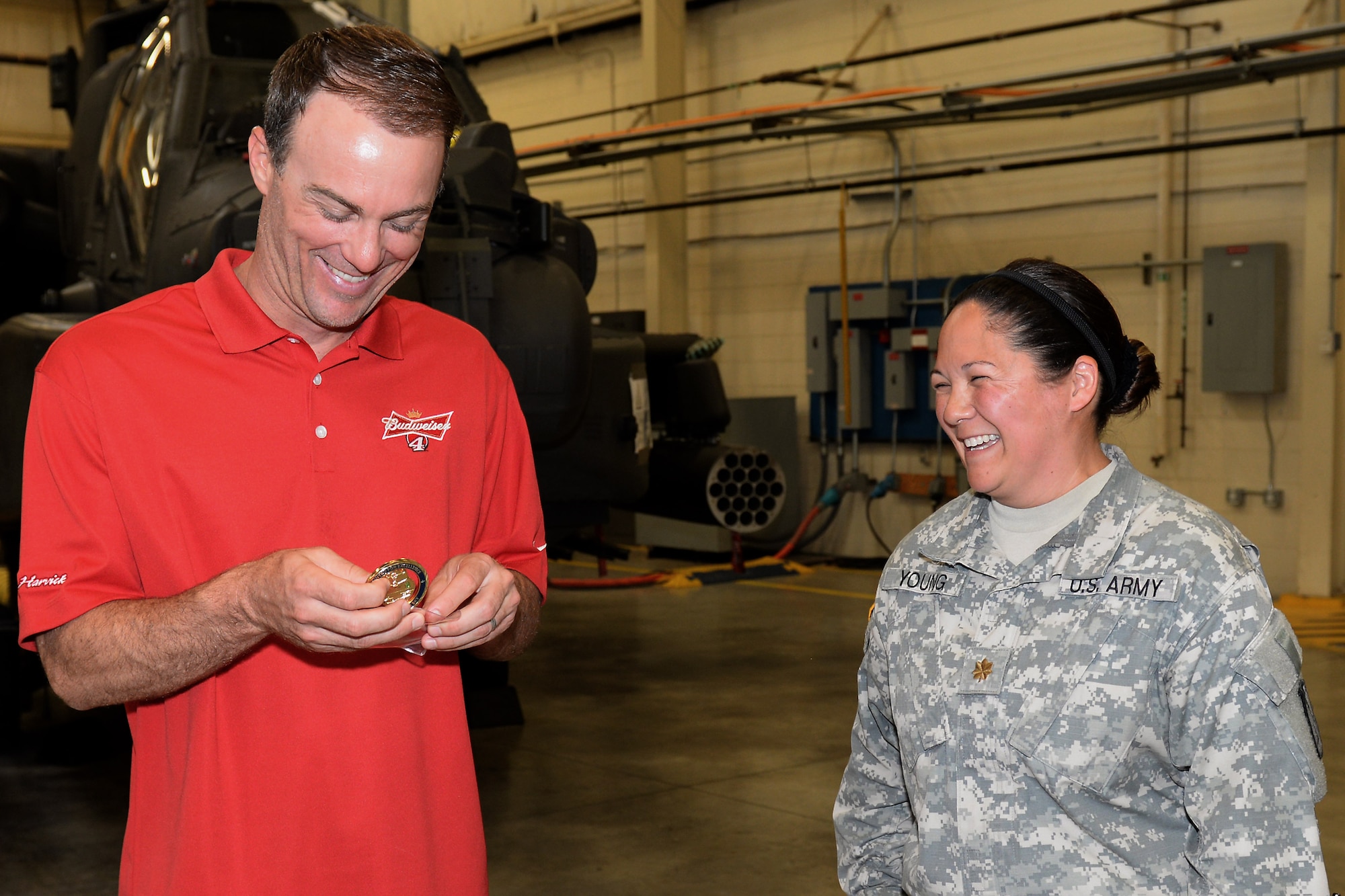Kevin Harvick, NASCAR driver, receives a coin from U.S. Army Maj. Joy Young, 1st Battalion, 210th Aviation Regiment operations officer, during a tour of the 128th Avn. Brigade at Fort Eustis, Va., Aug. 20, 2014. During his visit, Harvick toured the 3rd Port and visited the 7th Transportation Brigade (Expeditionary) Resolute Dining Facility and the Fort Eustis Exchange. (U.S. Air Force photo by Staff Sgt. Teresa J.C. Aber/Released)