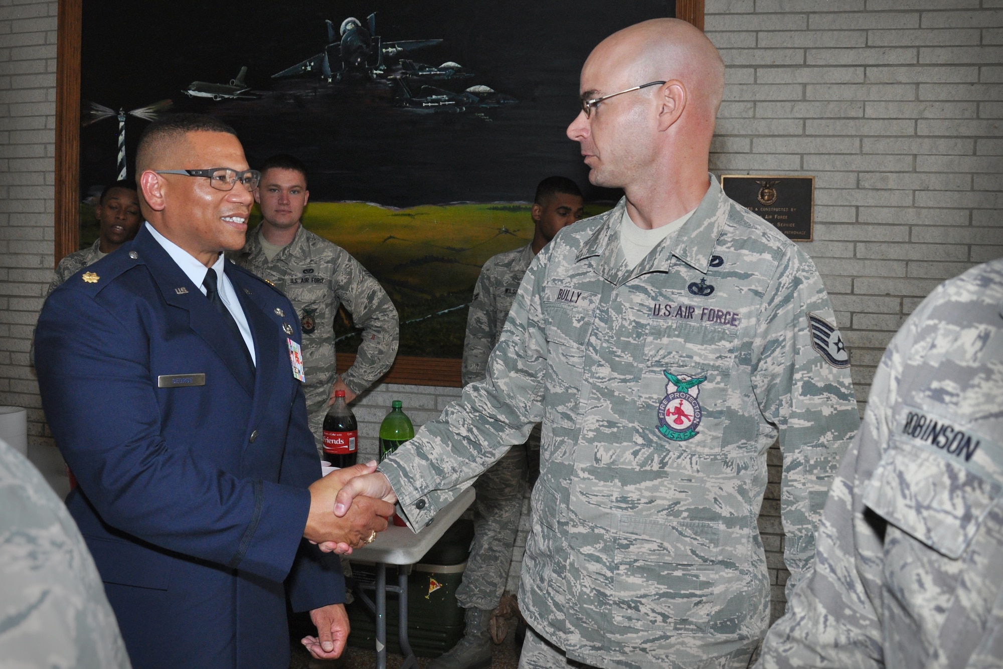 Maj. Oliver George, 916th Civil Engineer Flight commander, greets Staff Sgt. Ryan Bully, 916th CEF, during a reception after the 916th CEF change of command ceremony. Col. James Clutter relinquished command to George during the August 2014 drill weekend. (U.S. Air Force photo by Staff Sgt. Alan Abernethy)