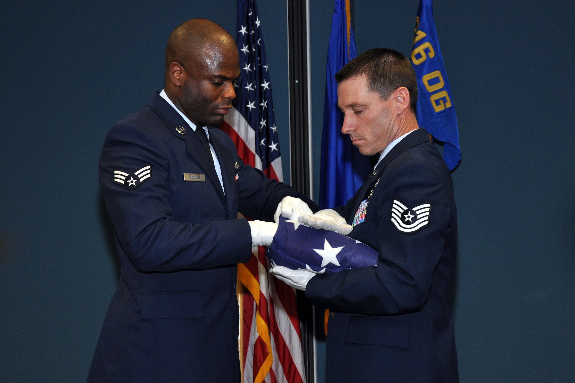 Tech. Sgt. Ian Gardner, 916th Operations Support Squadron, and Senior Airman Waco Douglas, 916th Force Support Squadron, perform a flag-folding ceremony for the retirement of Senior Master Sgt. Donna Lorenz, 916th logistics plans superintendent, Aug. 2014. (U.S. Air Force photo by Staff Sgt. Alan Abernethy)