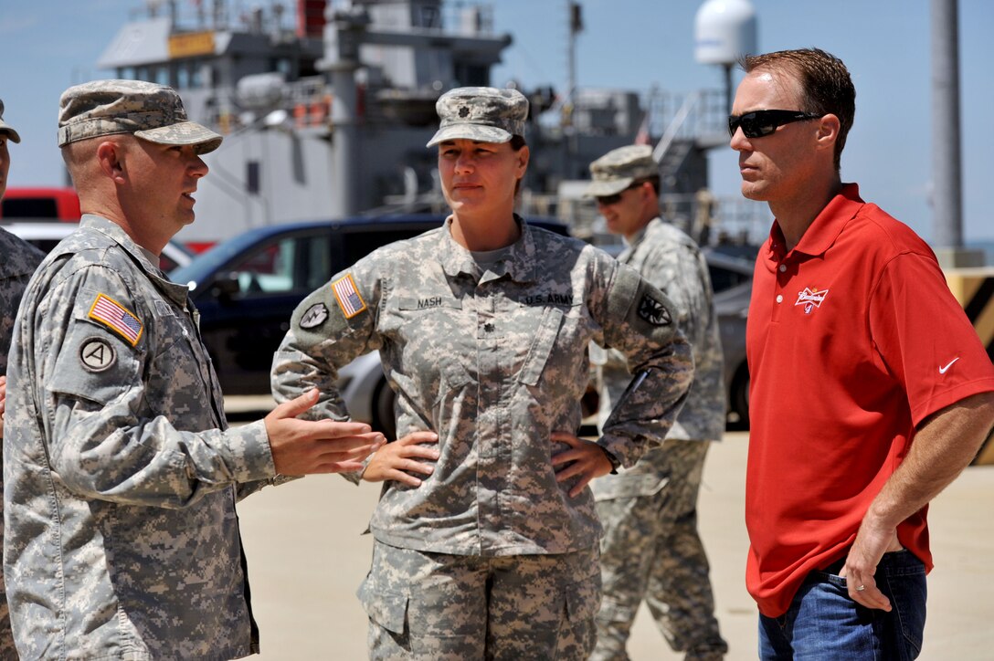 NASCAR driver Kevin Harvick, right, speaks with U.S. Army Chief Warrant Officer 2 John Willis, 7th Transportation Brigade (Expeditionary) watercraft operations officer, left, and Lt. Col. Kimberly Nash, 10th Trans. Bn., 7th Trans. Bde. (Ex) commander, center, during a visit to 3rd Port at Fort Eustis, Va., Aug. 20, 2014.  While at 3rd Port, Harvick boarded the Landing Craft Utility 2001 “Runnymede,” spoke with Soldiers, and received a tour and capabilities brief from Nash. (U.S. Air Force photo by Staff Sgt. Katie Gar Ward/Released) 