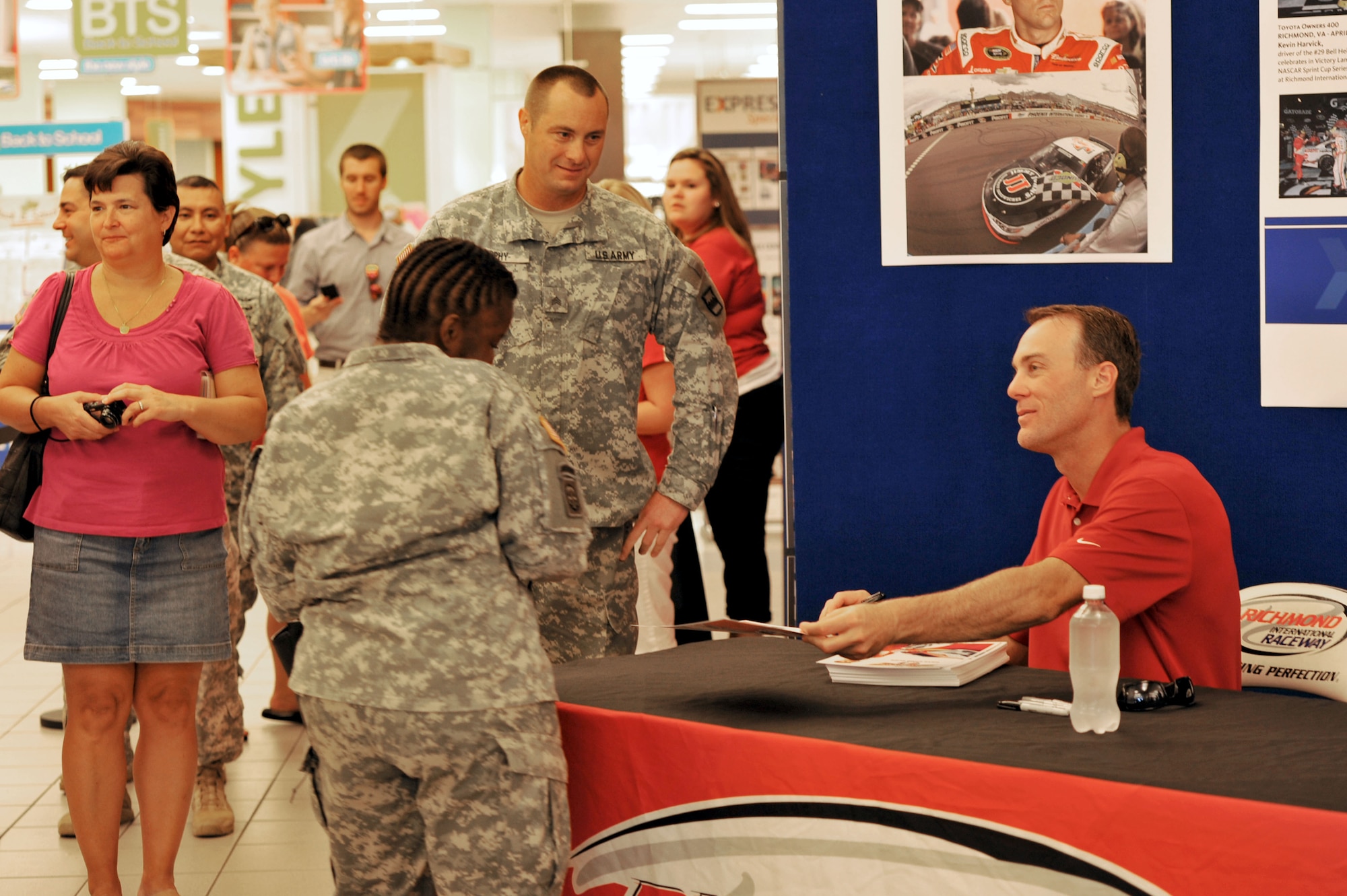 NASCAR driver Kevin Harvick, right, signs autographs for U.S. Army Soldiers and members of the Fort Eustis community and the Exchange at Fort Eustis, Va., Aug. 20, 2014.  While at Eustis, Harvick toured the 128th Aviation Brigade and 3rd Port, and visited the 7th Transportation Bde. (Expeditionary) Resolute Dining Facility. (U.S. Air Force photo by Staff Sgt. Katie Gar Ward/Released) 